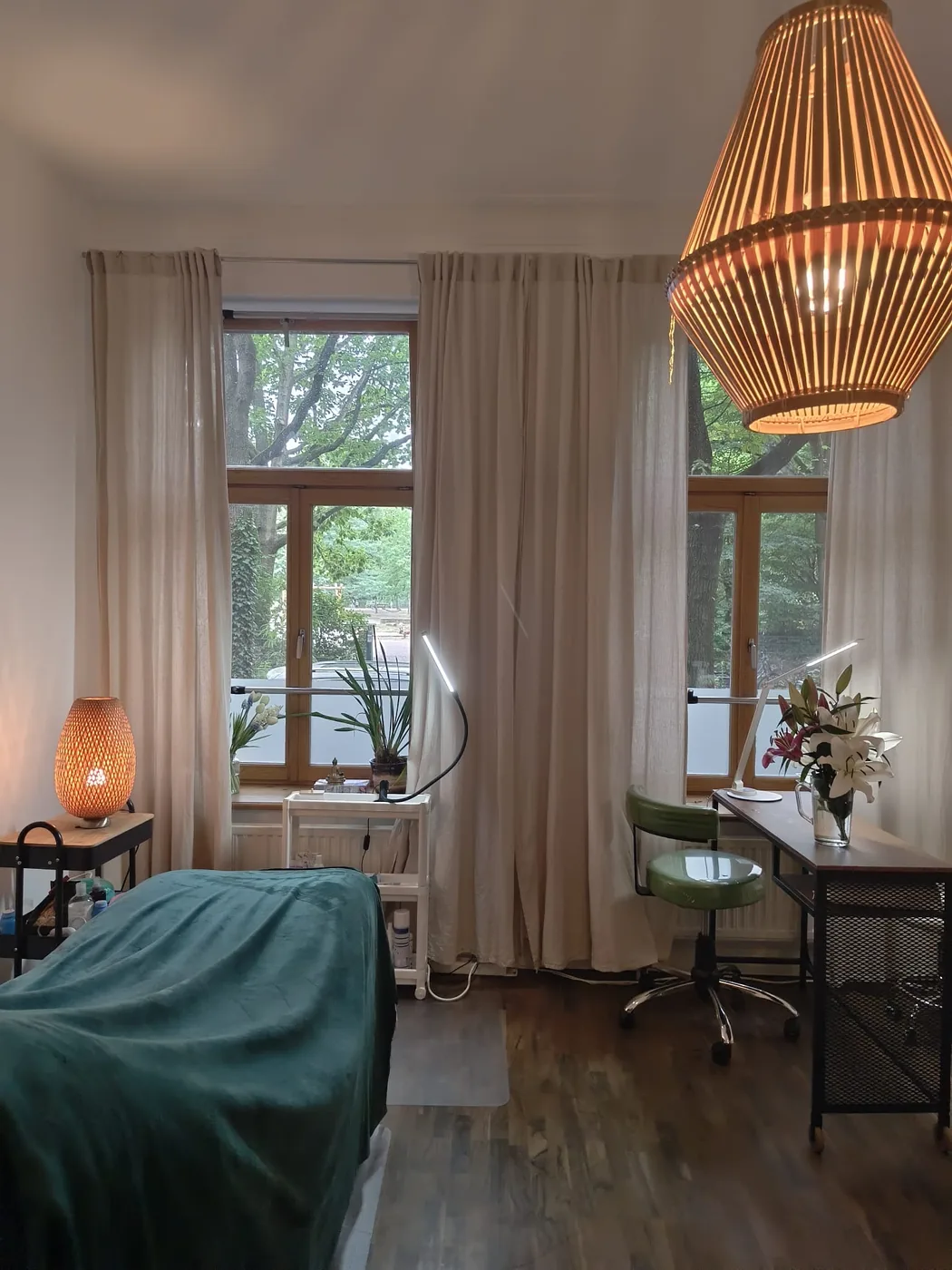 Behandlungsraum des TINGS TCM Beauty Studios mit Liege und Blick ins Grüne