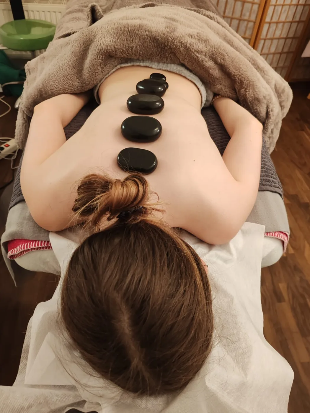Hot-Stone-Massage auf der Behandlungsliege